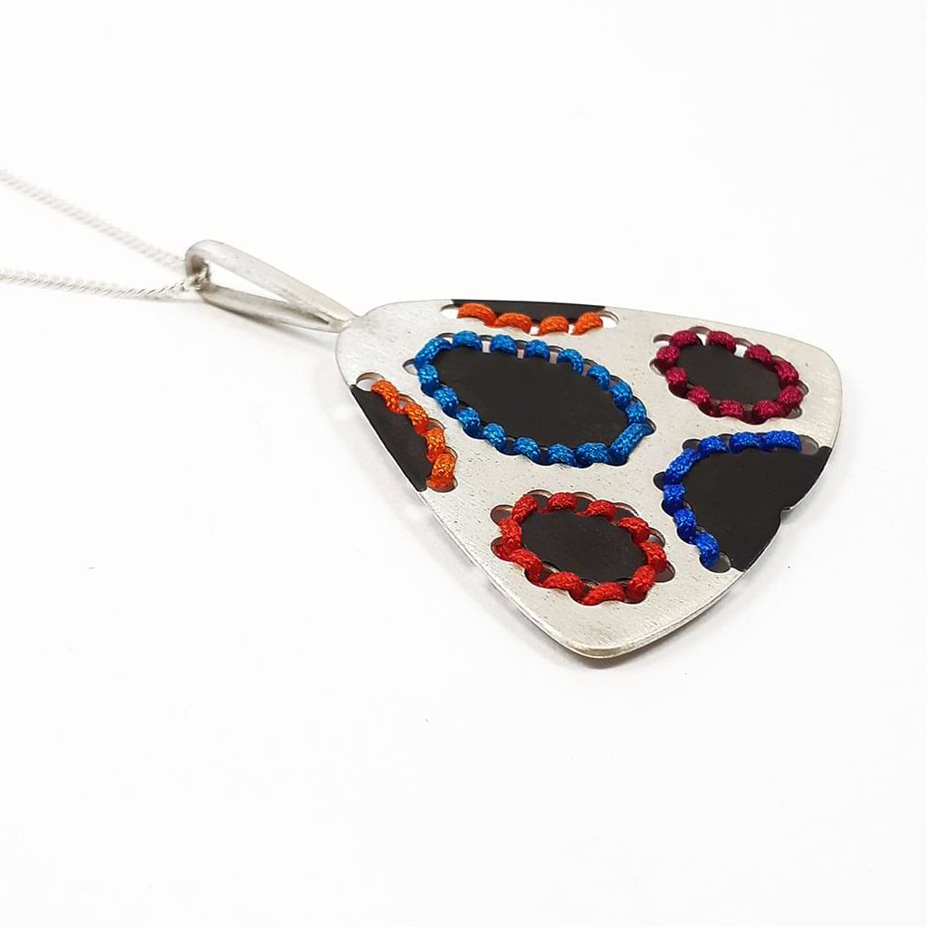 Katerina Malami. Triangular silver pendant with colored threads and oxidation, side view