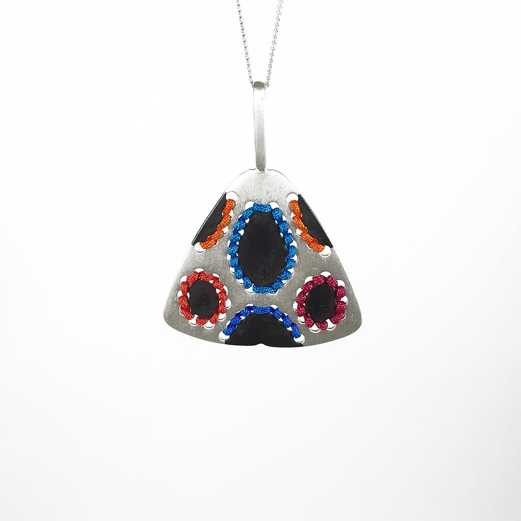 Katerina Malami. Triangular silver pendant with colored threads and oxidation.